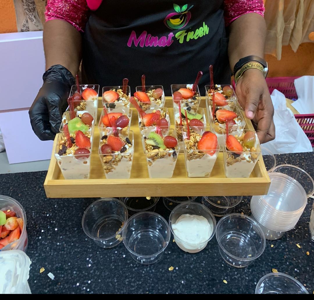 Minat Fresh staff serving a tray of fresh parfait cups at an event